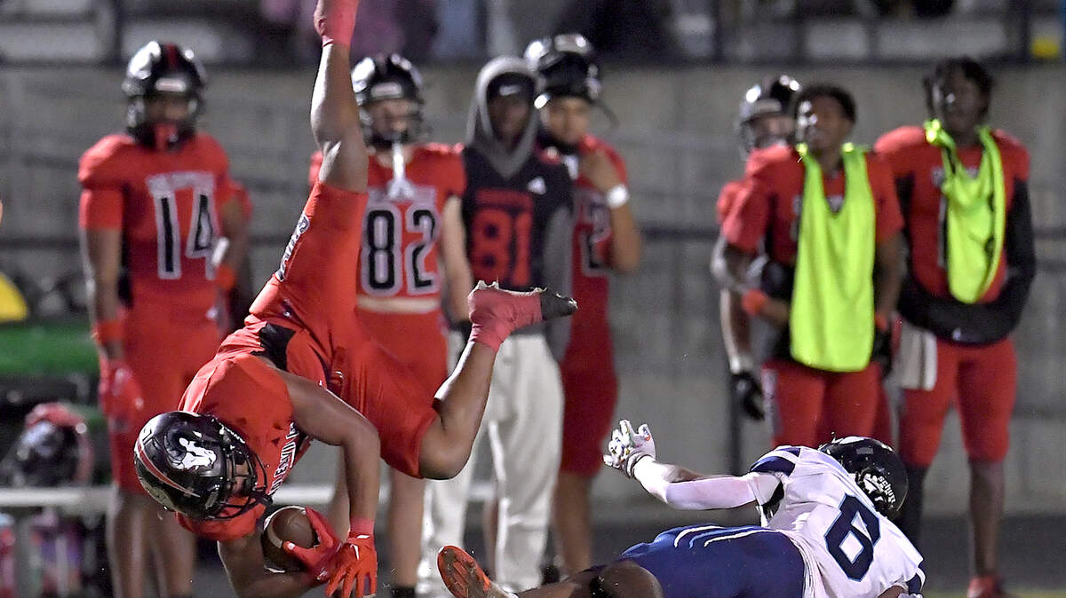 Rolesville running back Amir Brown (2) flips in the air after a tackle from Millbrook’s Nessiah McArthur (6) during the second half. The Rolesville Rams and the Millbrook Wildcats met in a football game in Raleigh. N.C. on October 11, 2024.