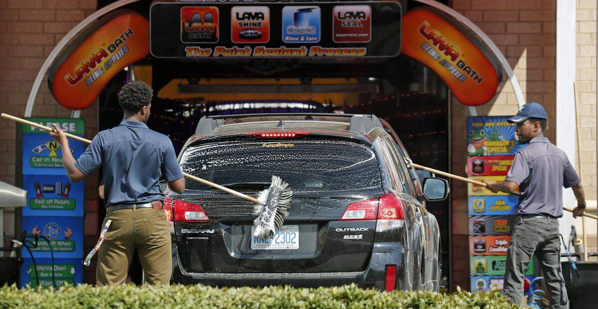 Workers put the preliminary cleaning touches on a pollen-laden car before it enters the car wash at the American Pride car wash on Wake Forest Rd. in Raleigh on April 3, 2018.  With the arrival of spring in the Triangle, pollen comes along, too.  For those obsessed with keeping their car clean of the yellow powder, the car wash offers a plan of unlimited car washes for a flat rate per month.