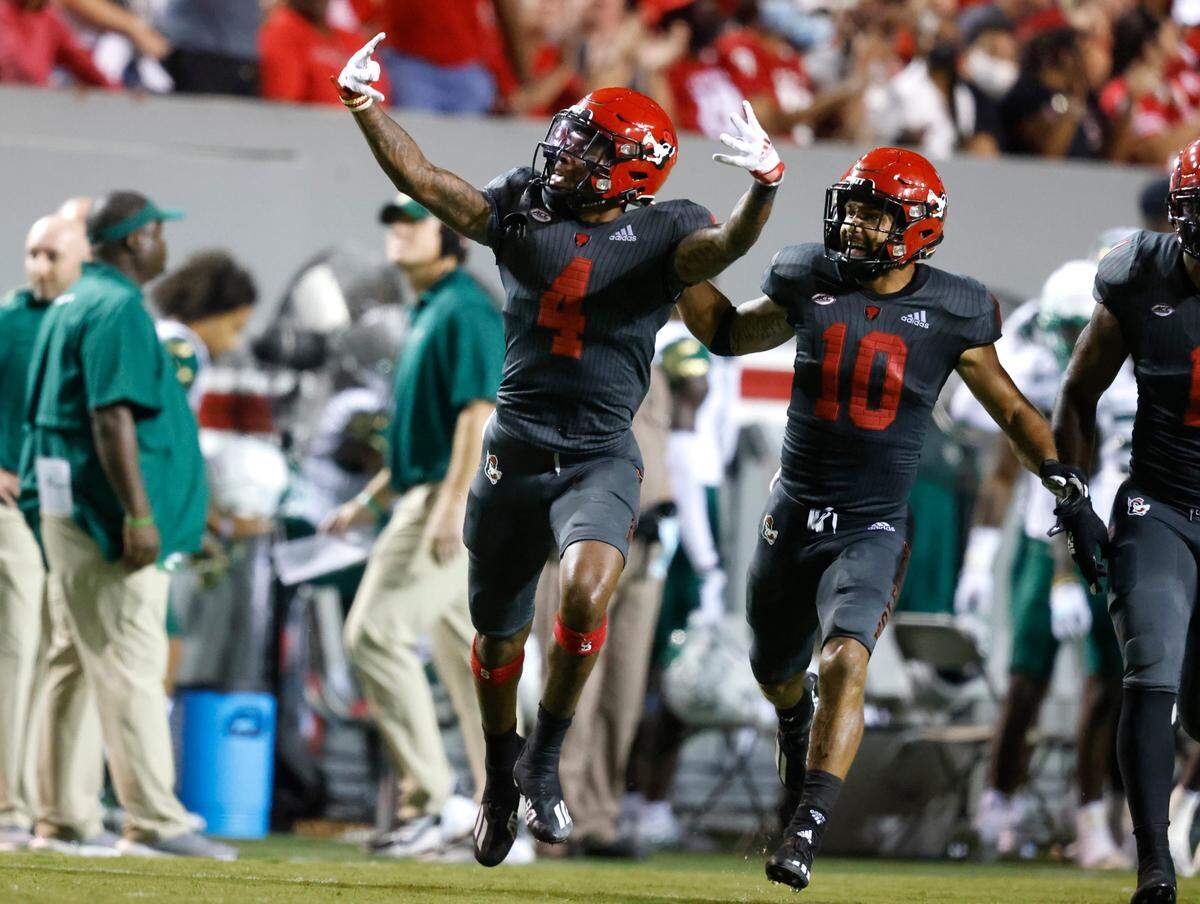N.C. State’s Cyrus Fagan (4) and Tanner Ingle (10) celebrate an interception by Fagan during the second half of N.C. State’s 45-0 victory over USF at Carter-Finley Stadium in Raleigh, N.C., Thursday, Sept. 2, 2021.