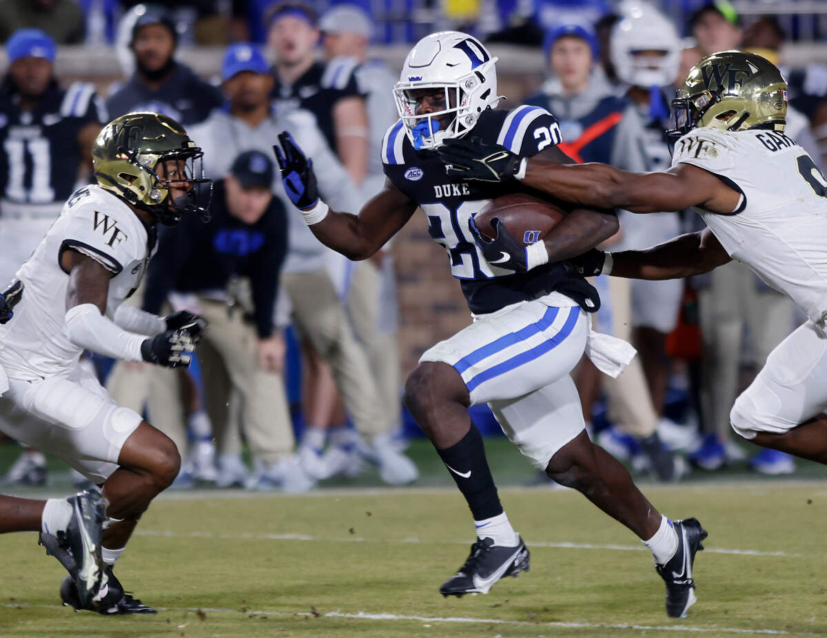 Duke’s Jaquez Moore runs the ball past Wake Forest’s Chelen Garnes during the second half of the Blue Devils’ final regular season game at Wallace Wade Stadium on Saturday, Nov. 26, 2022, in Durham, N.C.
