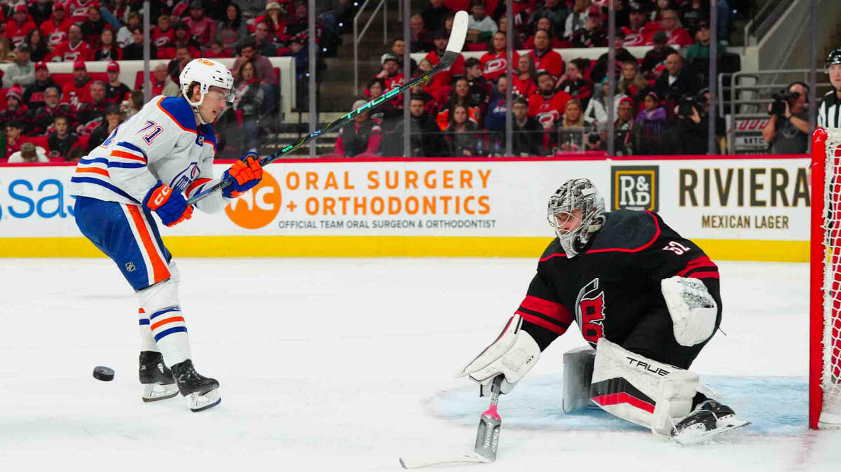 Carolina Hurricanes goaltender Pyotr Kochetkov (52) pokes the puck away from Edmonton Oilers center Ryan McLeod (71) during the second period at PNC Arena.