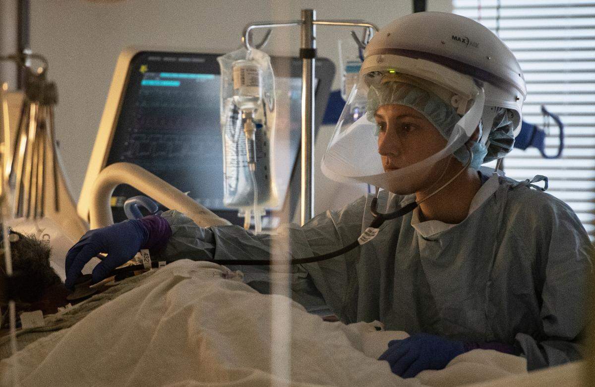 A nurse works with a Covid patient in the Medical Intensive Care Unit (MICU) at UNC Hospital in Chapel Hill on Thanksgiving Day, Thursday, Nov, 26, 2020.