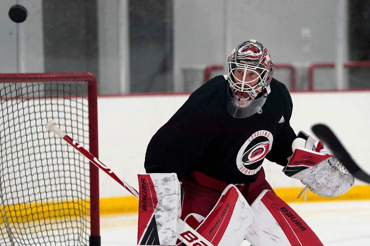 Carolina Hurricanes goalie James Reimer keeps an eye on the puck during NHL hockey training camp in Morrisville, N.C., Wednesday, Jan. 6, 2021. (AP Photo/Gerry Broome)
