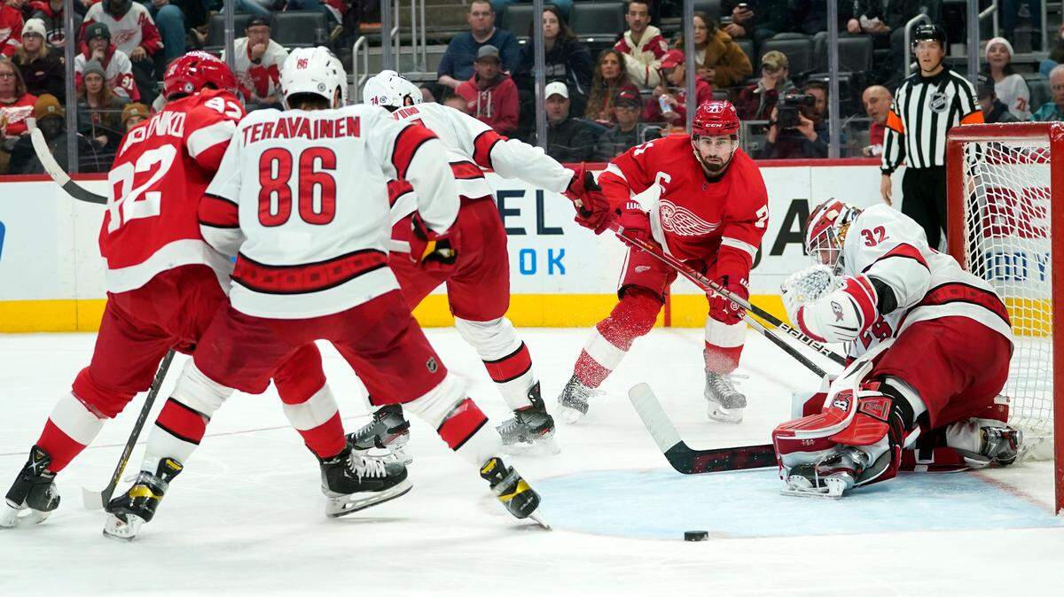 Carolina Hurricanes goaltender Antti Raanta (32) deflects a Detroit Red Wings center Dylan Larkin (71) shot in the second period of an NHL hockey game Tuesday, March 1, 2022, in Detroit. (AP Photo/Paul Sancya)
