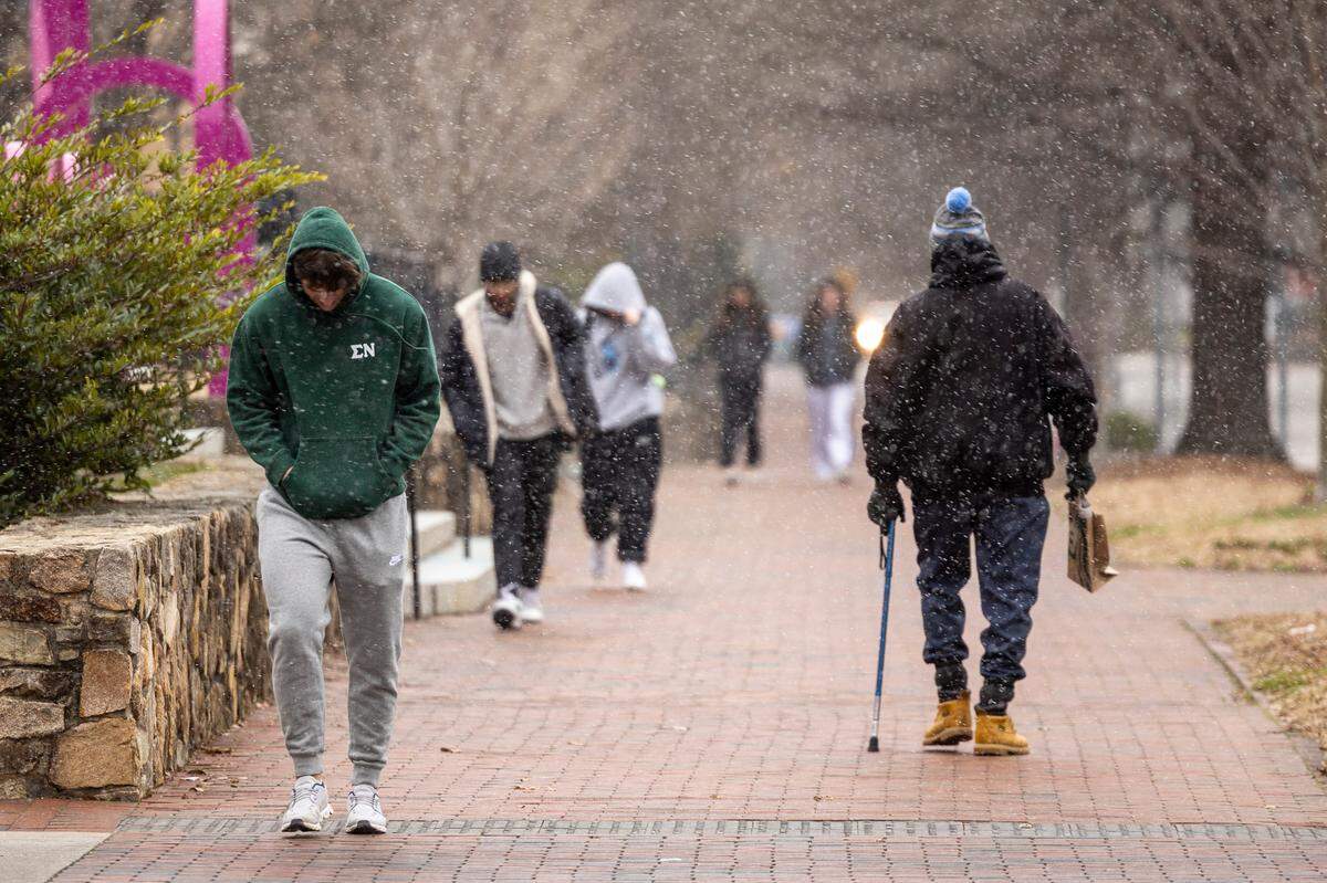 Pedestrians brave the freezing temperature as snow begins to fall at UNC-Chapel Hill on Wednesday, Feb. 19, 2024.