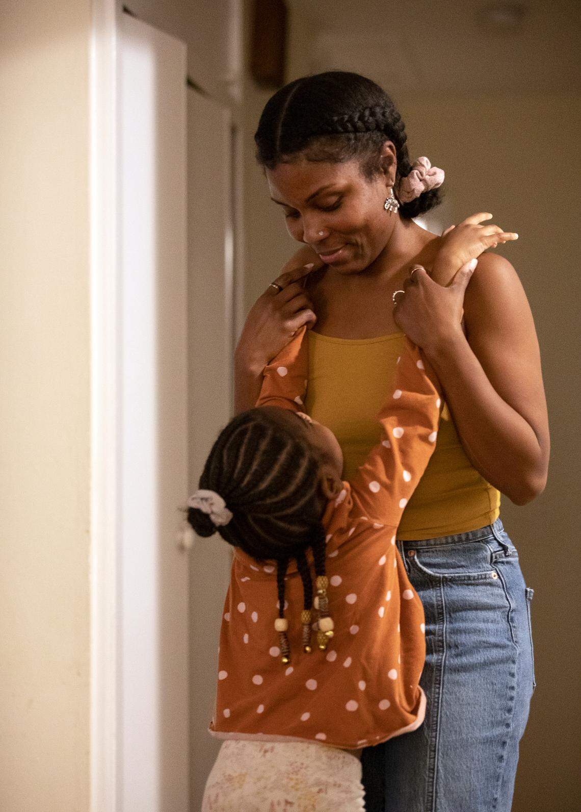 Sheba Everett hugs her daughter, Hannah Edgerton, 5, at their home in Durham, N.C. on Wednesday, Oct. 26, 2022. After renting the house where she lives with her five daughters for over two years, Everett received a notice to vacate by May 31, 2023. The Eno River Association, which owns this home and six others nearby, plans to transfer the property to the state.