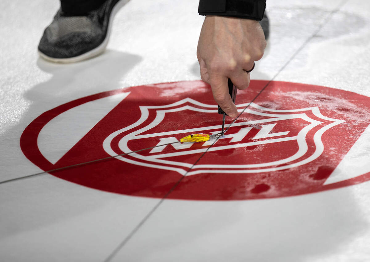 A crew works to install lines and logos as preparations continue for the Carolina Hurricanes’ Stadium Series game against the Washington Capitals on Monday, Feb. 13, 2023, at Carter-Finley Stadium in Raleigh, N.C.