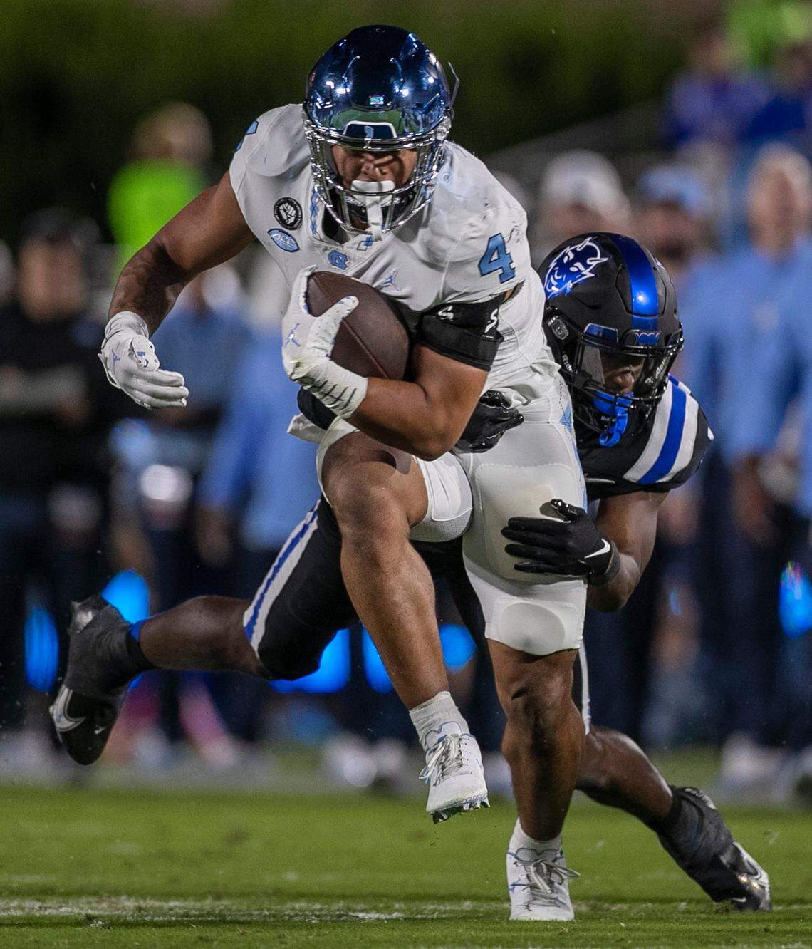 North Carolina’s Caleb Hood (4) rushes for 13 yards in the first quarter against Duke’s Darius Joiner (1) on Saturday, October 15, 2022 at Wallace-Wade Stadium in Durham, N.C.