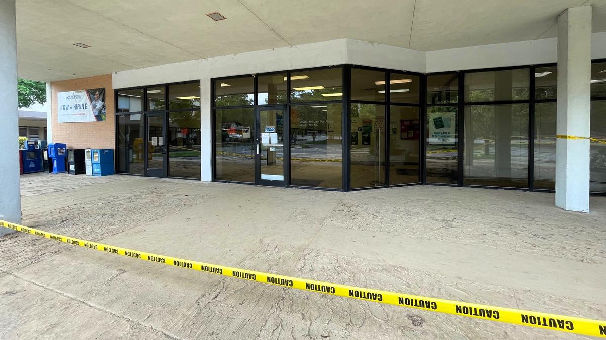 Yellow caution tape remains loosely wrapped around the front entrance of the U.S. Post Office on South Estes Drive in Chapel Hill. The post office could be closed for a month while it’s being renovated after major flooding, a USPS spokesperson said.