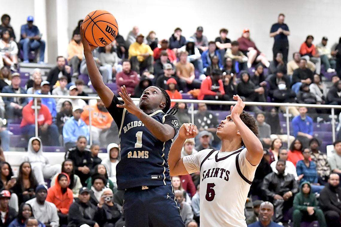 Reidsville’s Dionte Neal (1) goes for the layup against St. Anne’s-Belfield’s Austin Williford (5) during the second half. The Reidsville Rams and the St. Anne -Belfield (VA) Saints met in the finals of the Day’Ron Sharpe bracket of the John Wall Holiday Invitational in Raleigh, N.C. on December 30. 2024.