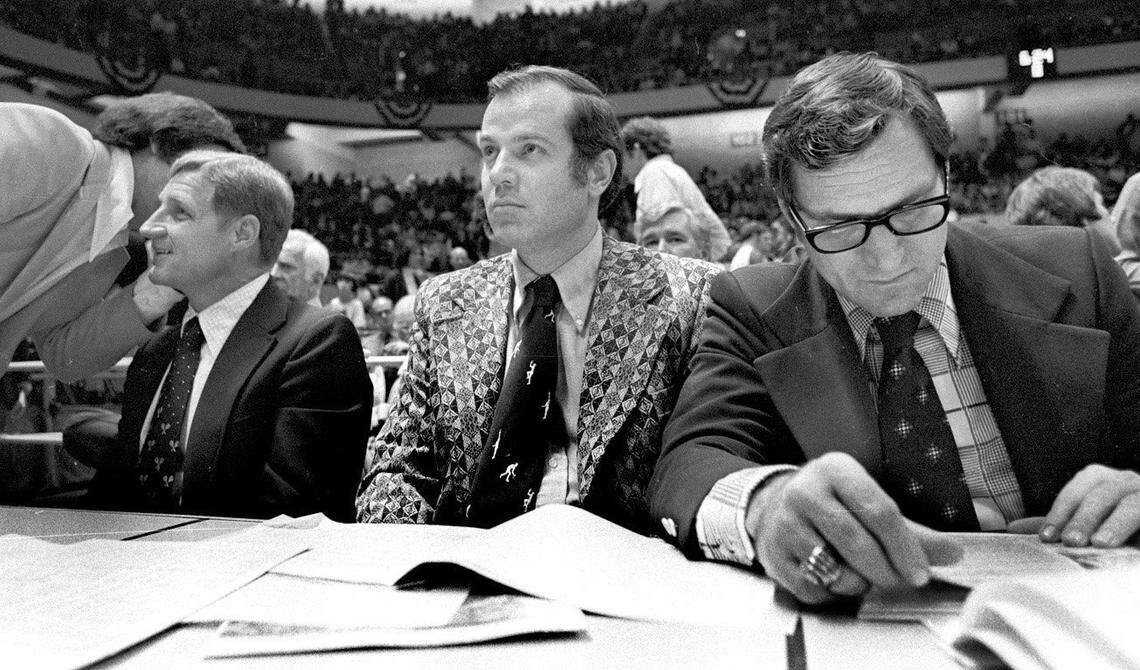 UNC coach Dean Smith, right, reviews stats as he sits with assistant coach Bill Guthridge, middle, and NC State head coach Norm Sloan, left, at the 1974 ACC Tournament in Greensboro, NC.