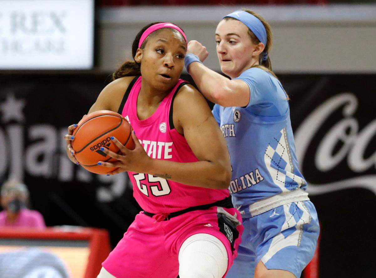 N.C. State’s Kayla Jones (25) gets around North Carolina’s Alyssa Ustby (1) during the first half of N.C. State’s game against UNC in the annual Play4Kay game at Reynolds Coliseum in Raleigh, N.C., Sunday, February 21, 2021.