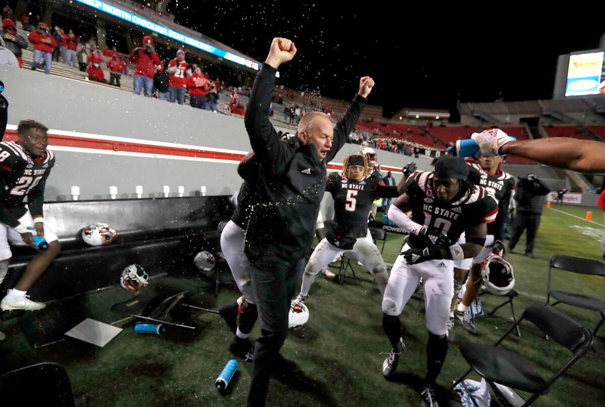 N.C. State head coach Dave Doeren is sprayed with water as he celebrates with the defense in the final seconds of N.C. State’s 23-13 victory over Georgia Tech at Carter-Finley Stadium in Raleigh, N.C., Saturday, Dec. 5, 2020.
