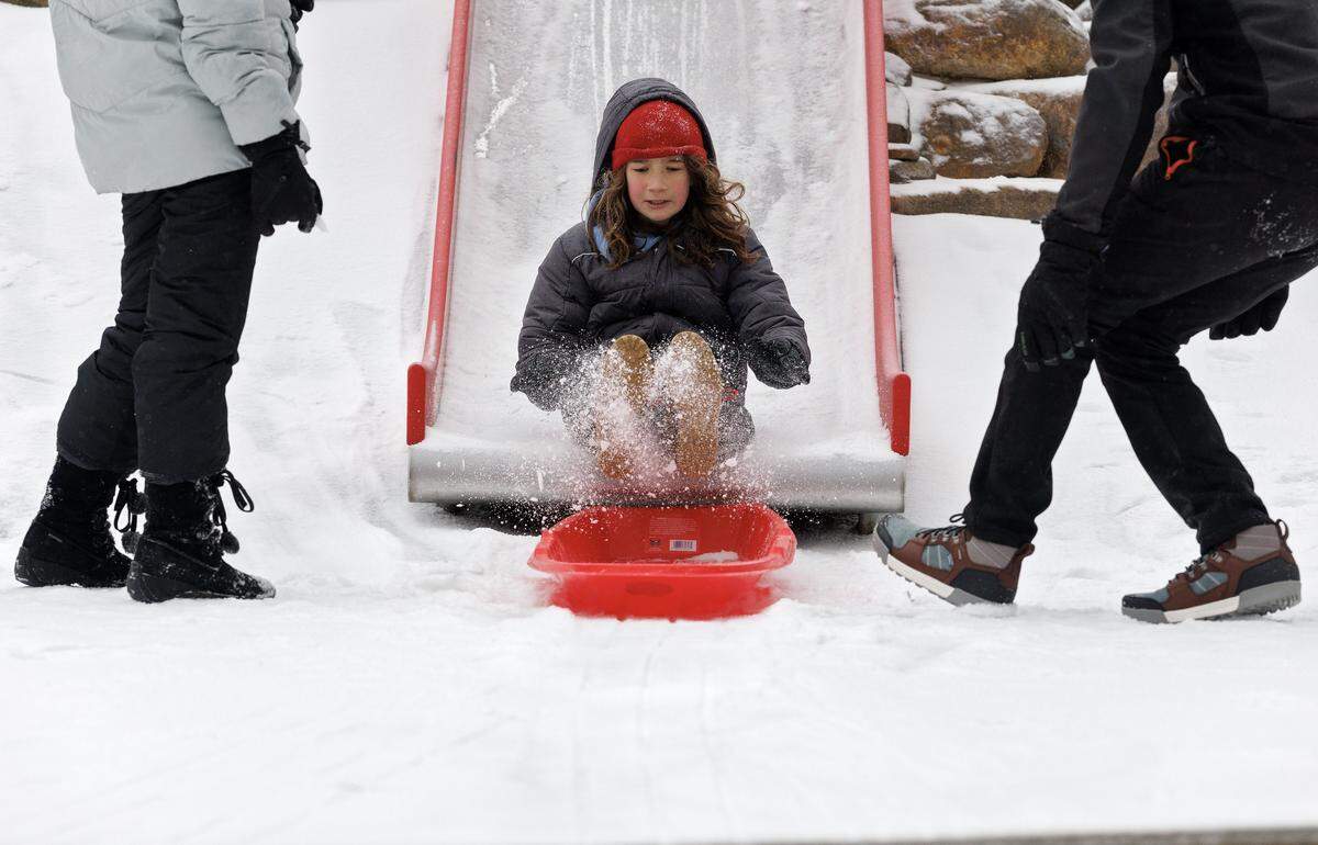 Sean Valle, 9, launches from an ice-covered slide to a sled in Durham Central Park on Sunday, January 25, 2026.