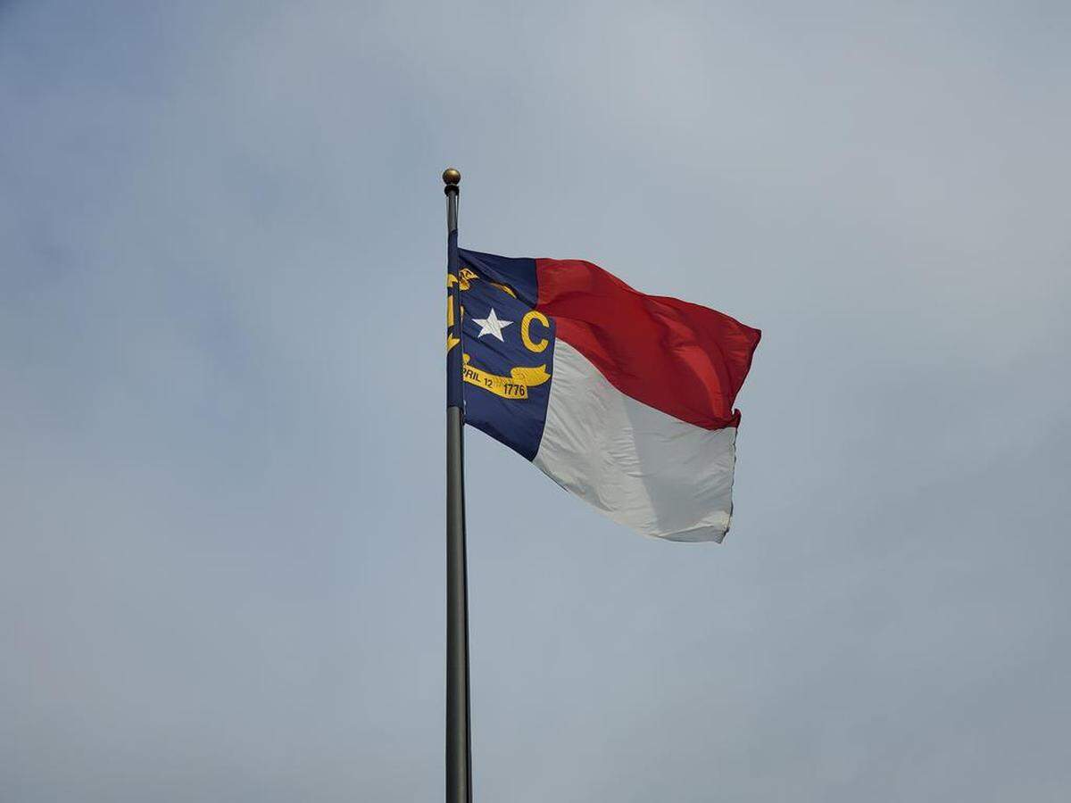 The North Carolina state flag, pictured here blowing in the wind on May 12, 2022, on a flagpole outside the Legislative Building in downtown Raleigh.