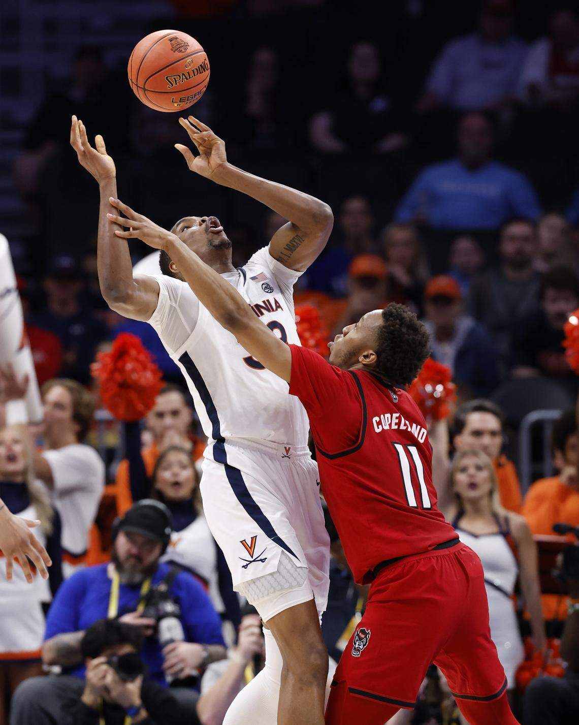 Virginia's Ugonna Onyenso (33) pulls the ball in after N.C. State's Quadir Copeland (11) knocked it away in the second half of Virginia’s 81-74 victory over N.C. State in the quarterfinals of the 2026 ACC Men’s Basketball Tournament at the Spectrum Center in Charlotte, N.C., Thursday, March 12, 2026.