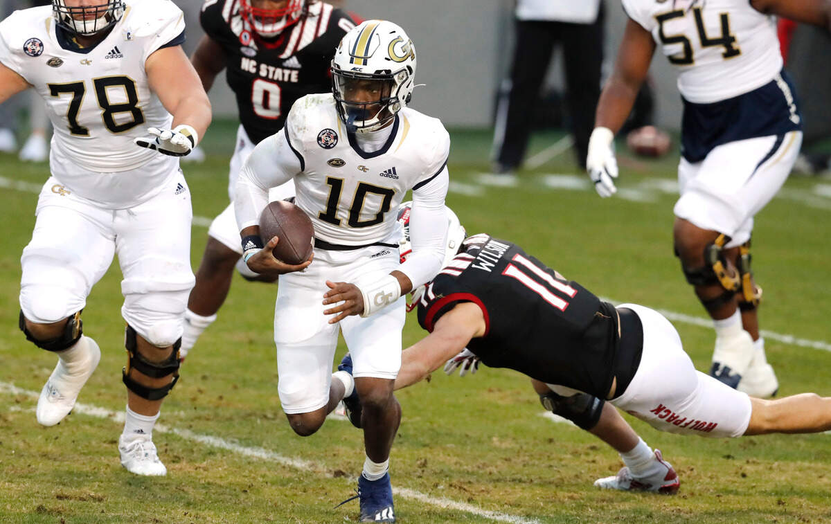 Georgia Tech quarterback Jeff Sims (10) escapes N.C. State linebacker Payton Wilson (11) as he gains yards during the first half of N.C. State’s game against Georgia Tech at Carter-Finley Stadium in Raleigh, N.C., Saturday, Dec. 5, 2020.