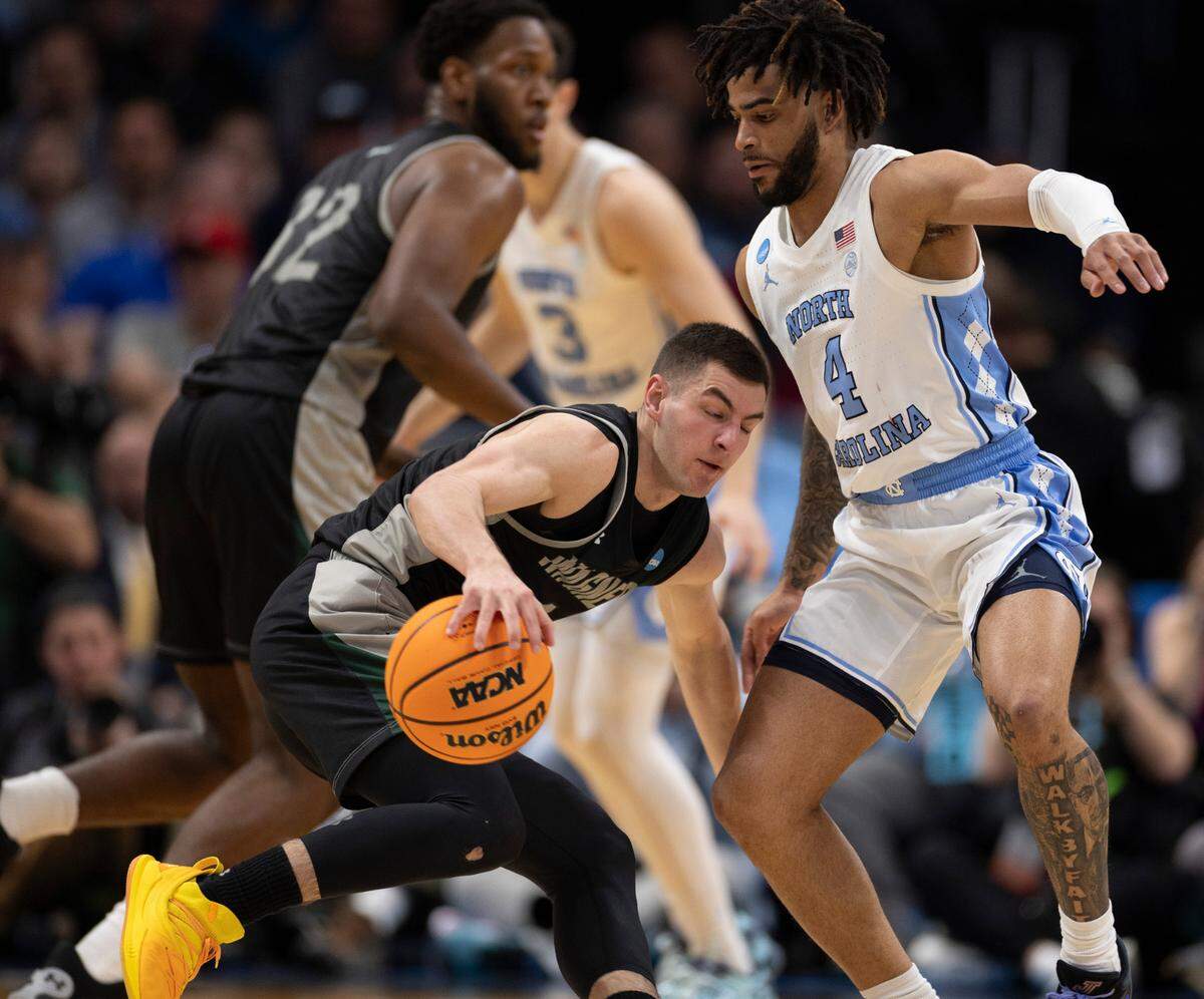 North Carolina’s R.J. Davis (4) defends Wagner’s Javier Ezquerra (1) in the first half on Thursday, March 21, 2024 during the NCAA Tournament at Spectrum Center in Charlotte, N.C.