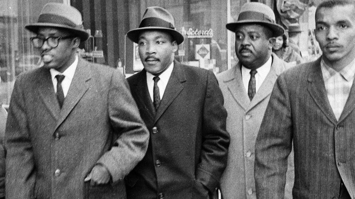 Rev. Douglas Moore, pastor of the Asbury Temple Methodist Church, Dr. Martin Luther King Jr., Rev. Ralph Abernathy and NCCU student Lacy Streeter walk along West Main Street on their way to the Woolworth Lunch Counter in this file photo from Feb. 16, 1960.
