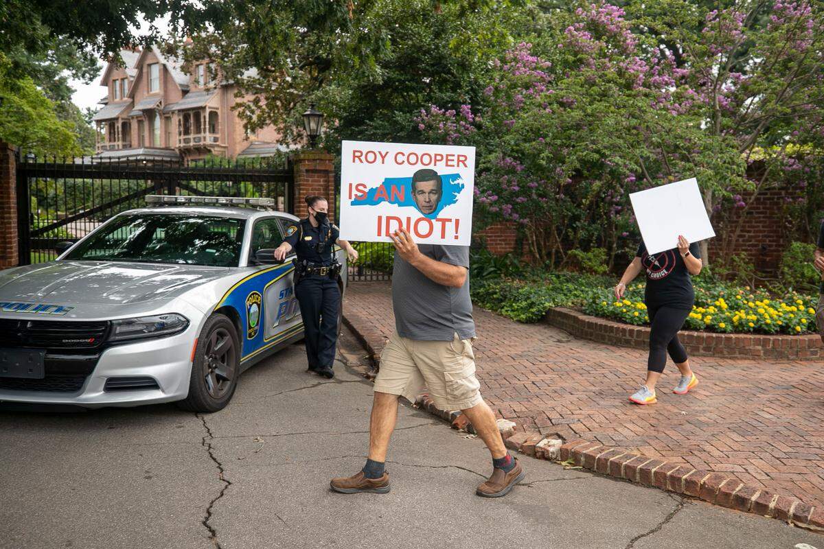 Demonstrators march around The Executive Mansion calling for an end to mandated masks and COVID-19 vaccinations by some employers and schools on Wednesday morning, August 4, 2021 in Raleigh, N.C. In August, there was no statewide mask mandate but many towns, cities and counties had them in place.