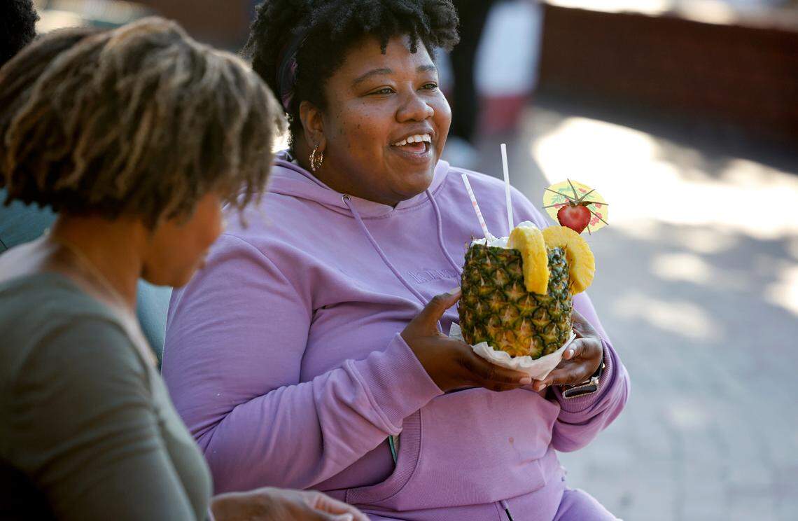 Adrienne Smith, right, and Kristen White, both of Dunn, take a break to enjoy their food at the N.C. State Fair in Raleigh, N.C., Thursday, Oct. 12, 2023.