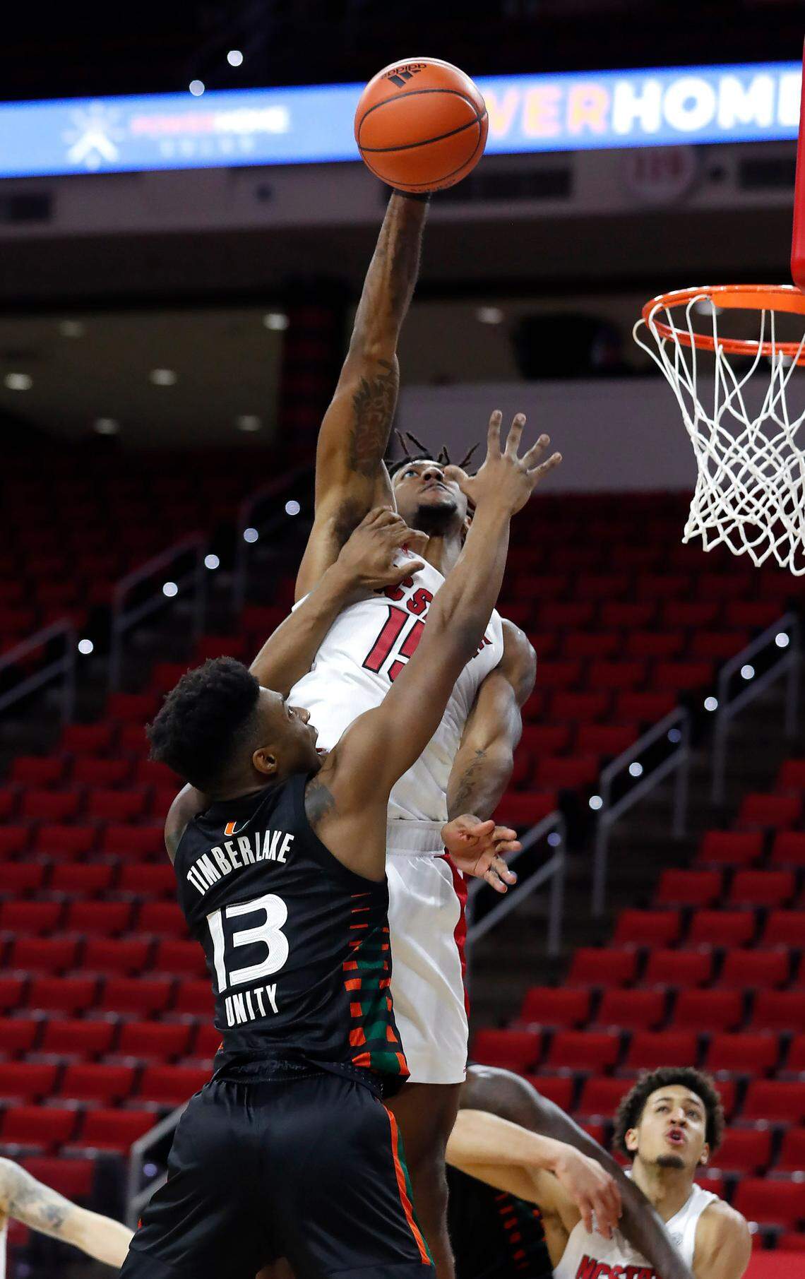 N.C. State’s Manny Bates (15) blocks the shot by Miami’s Earl Timberlake (13) during the first half of N.C. State’s game against Miami at PNC Arena in Raleigh, N.C., Saturday, January 9, 2021.