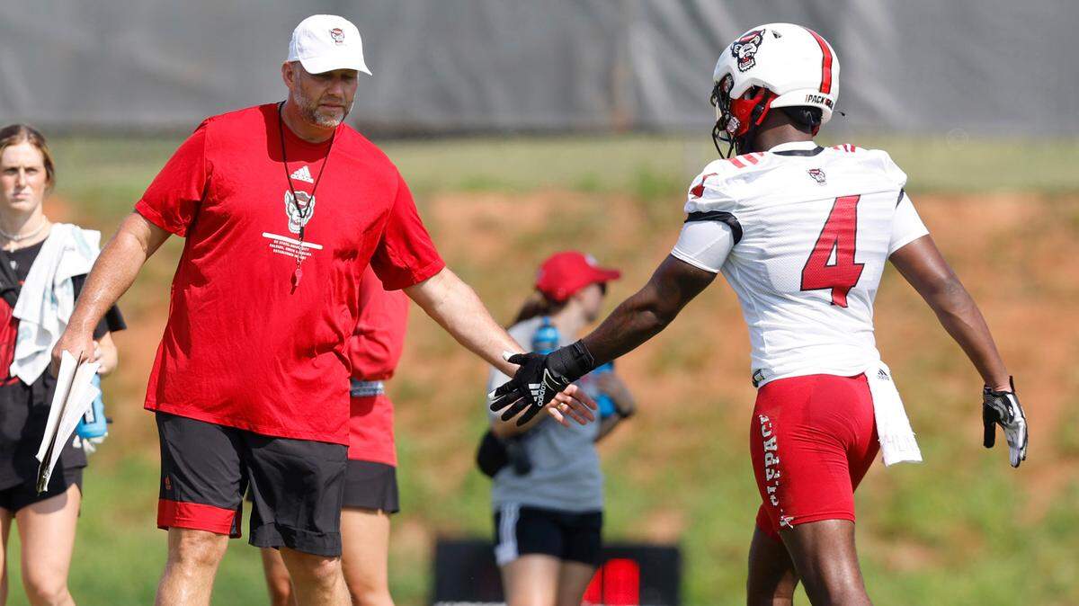 N.C. State head coach Dave Doeren congratulates wide receiver Porter Rooks (4) during the Wolfpack’s first practice of fall camp in Raleigh, N.C., Wednesday, August 3, 2022.