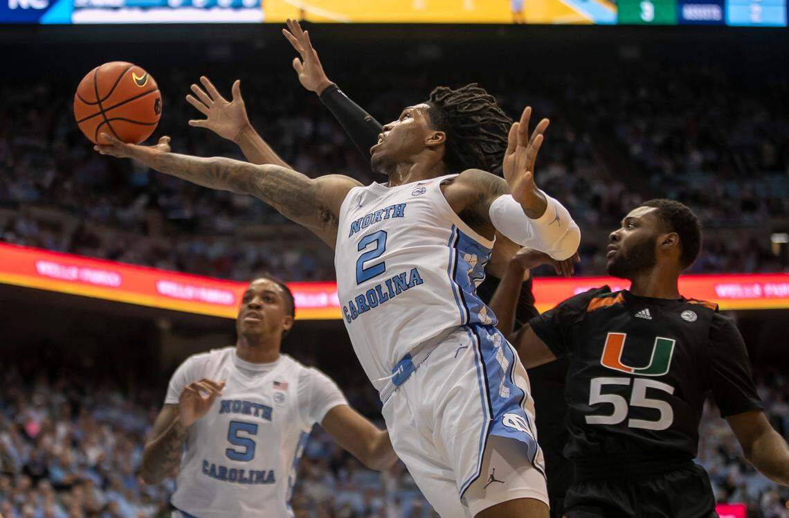 North Carolina’s Caleb Love (2) breaks to the basket past Miami’s Wooga Poplar (55) in the first half on Monday, February 13, 2023 at the Smith Center in Chapel Hill, N.C.