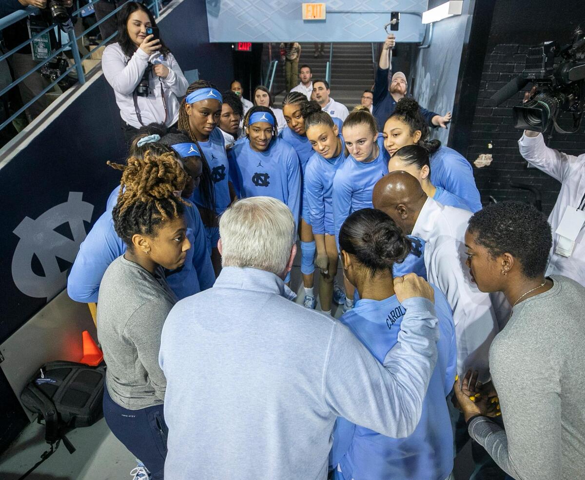 North Carolina football coach Mack Brown huddles with the Tar Heel women’s basketball team prior to their game against N. C. State on Sunday, January 15, 2023 at Carmichael Arena in Chapel Hill, N.C.