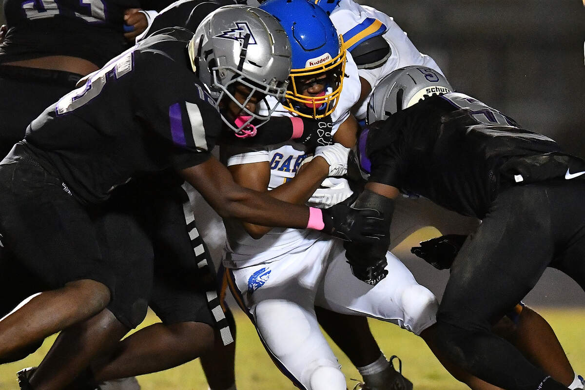 South Garner linebacker's Jimi Sonaiya (10) and Armez Phelps (15) tackle Garner running back Amir Wallace (4) during the first half. The South Garner Titans and the Garner Trojans met in a conference football game in Raleigh, N.C. October 17, 2025