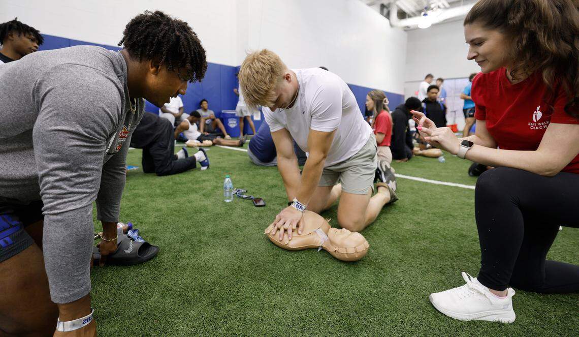 Katie Belusa works with Duke linebacker Kendall Johnson, left, and tight end Vance Bolyardon while doing CPR training at the Yoh Football Building in Durham, N.C., Tuesday, July 22, 2025. The football team received the CPR training by members of the American Heart Association of the Triangle and Eastern North Carolina.