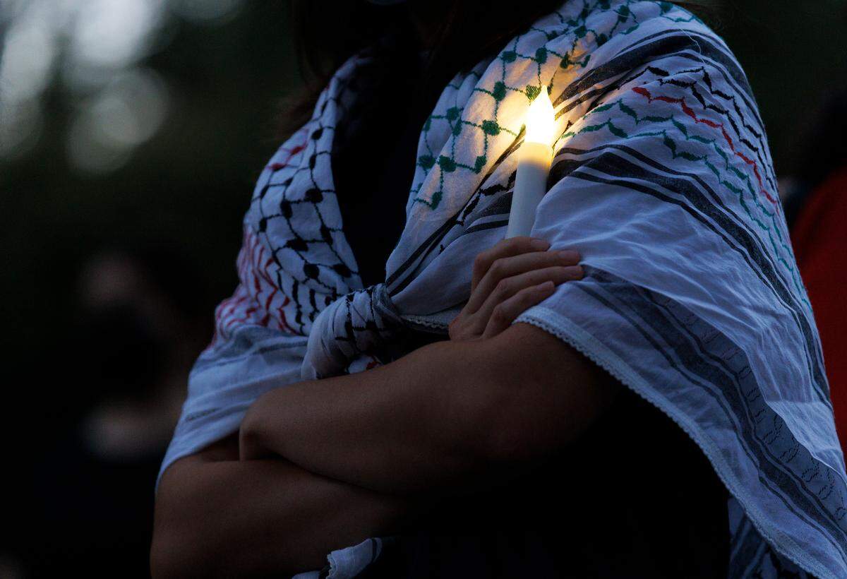A person holds a candle during a vigil held by the UNC chapter of Students for Justice in Palestine on Monday, Oct. 7, 2024, in Chapel Hill, N.C. The vigil was intended to honor those who have been killed during Israel’s counter-campaign against Hamas in the past year.