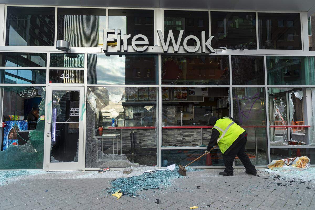 Broken glass is swept by workers on Fayetteville St. after protestors vandalized many downtown businesses Saturday night in response to the death of George Floyd in the custody of Minneapolis Police on Monday, joining protestors in major cities across the country, on Sunday, May 31, 2020, in Raleigh, N.C.