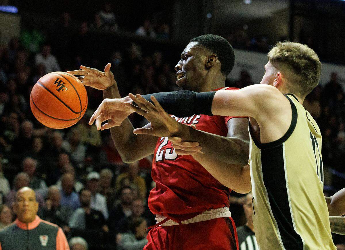 N.C. State’s Mohamed Diarra and Wake Forest’s Andrew Carr battle for possession during the second half of the Wolfpack’s 83-79 loss on Saturday, Feb. 10, 2024, at Lawrence Joel Veterans Memorial Coliseum in Winston-Salem, N.C.