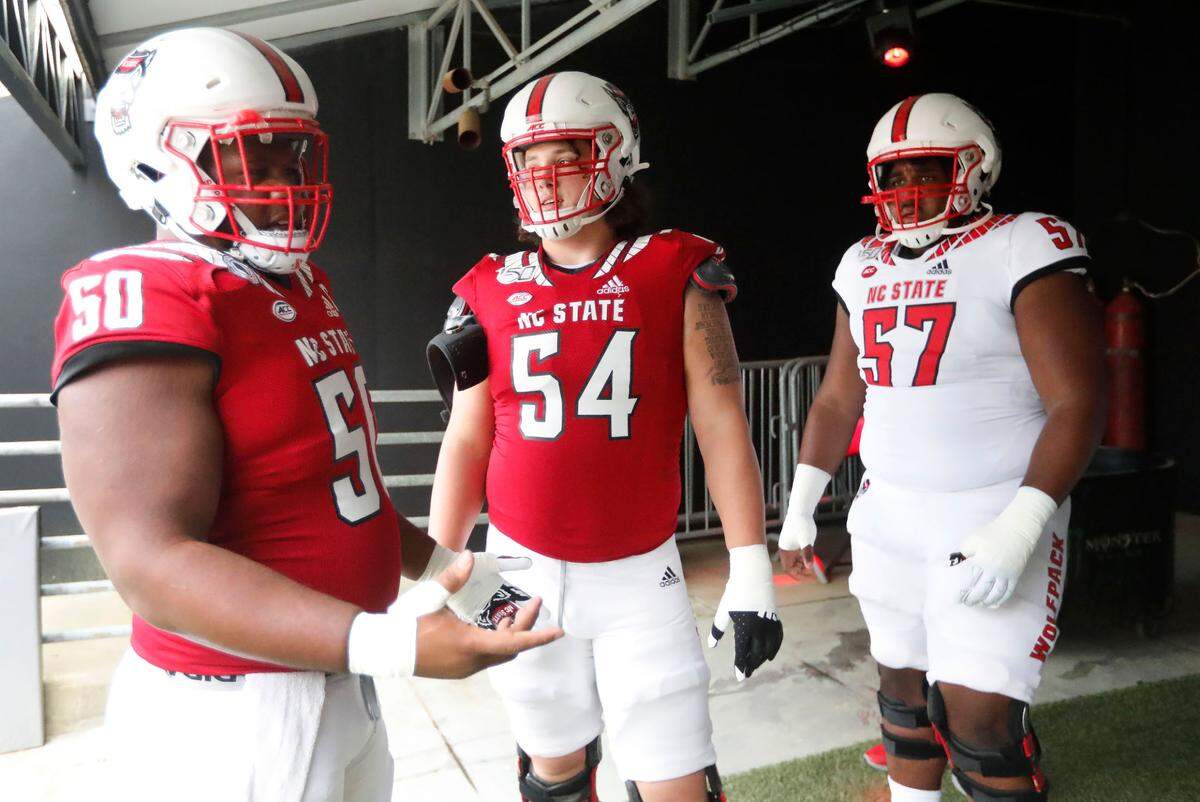 N.C. State’s Lyndon Cooper (57), right, along with Grant Gibson (50), left, and Dylan McMahon (54) prepare to head onto the field to warmup before the Wolfpack’s spring game at Carter-Finley Stadium in Raleigh, N.C., Saturday, April 10, 2021.