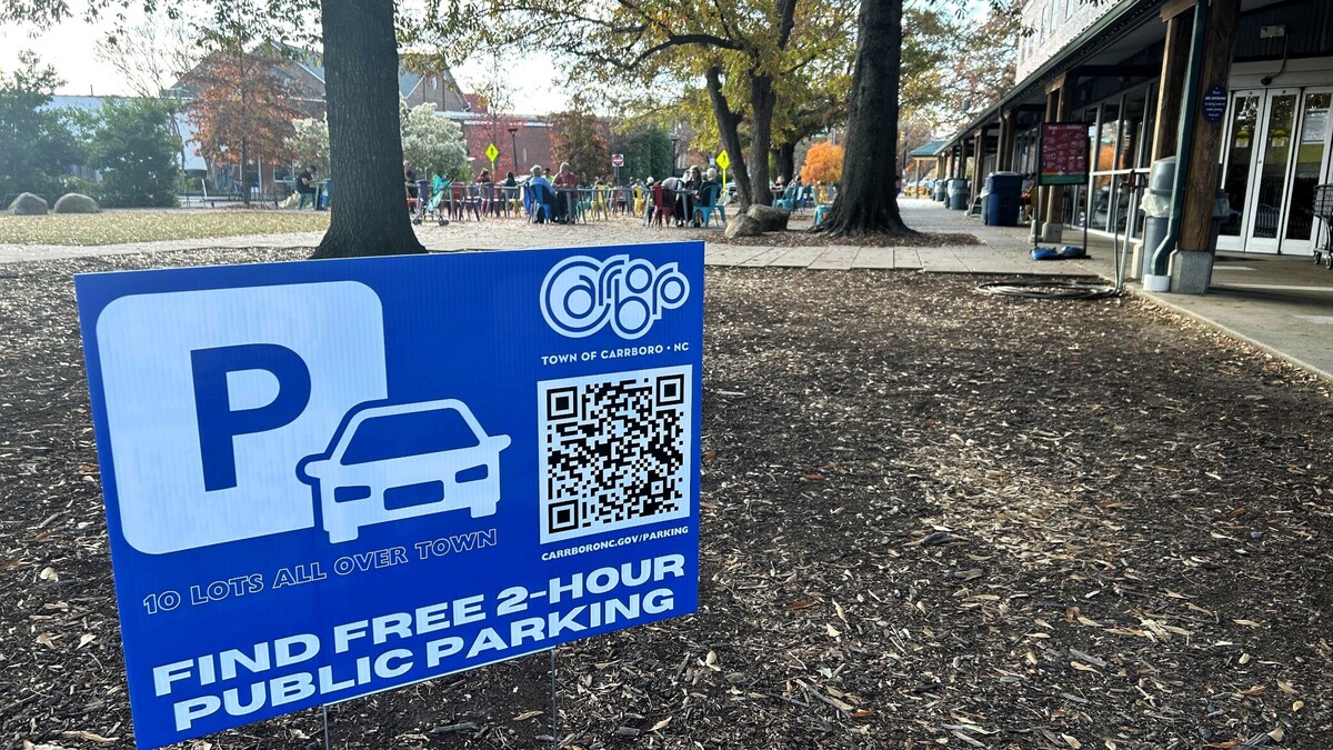 Carrboro town staff put up these signs in 2023 to direct drivers to free public parking lots after dozens of cars were towed from private downtown lots, including the parking lot at Weaver Street Market. The town is now considering a fee for parking in public lots.