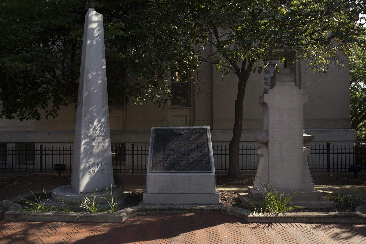 In 1921, a statue (far-right) was erected to honor World War I soldiers from Durham who died during the war between 1917-1919. When commissioned, the statue listed the names of white soldiers separately from the names of Black soldiers. In March 2021, a commemorative sign was installed to combine the names of Durham white and Black soldiers who died in the war.
