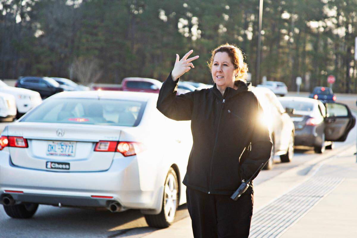 Swift Creek Middle School principal Kerri Evans directs traffic during Monday morning’s drop-off on Feb. 21, 2022, in Clayton. This marks the first day that masks may be optional in Johnston County schools.