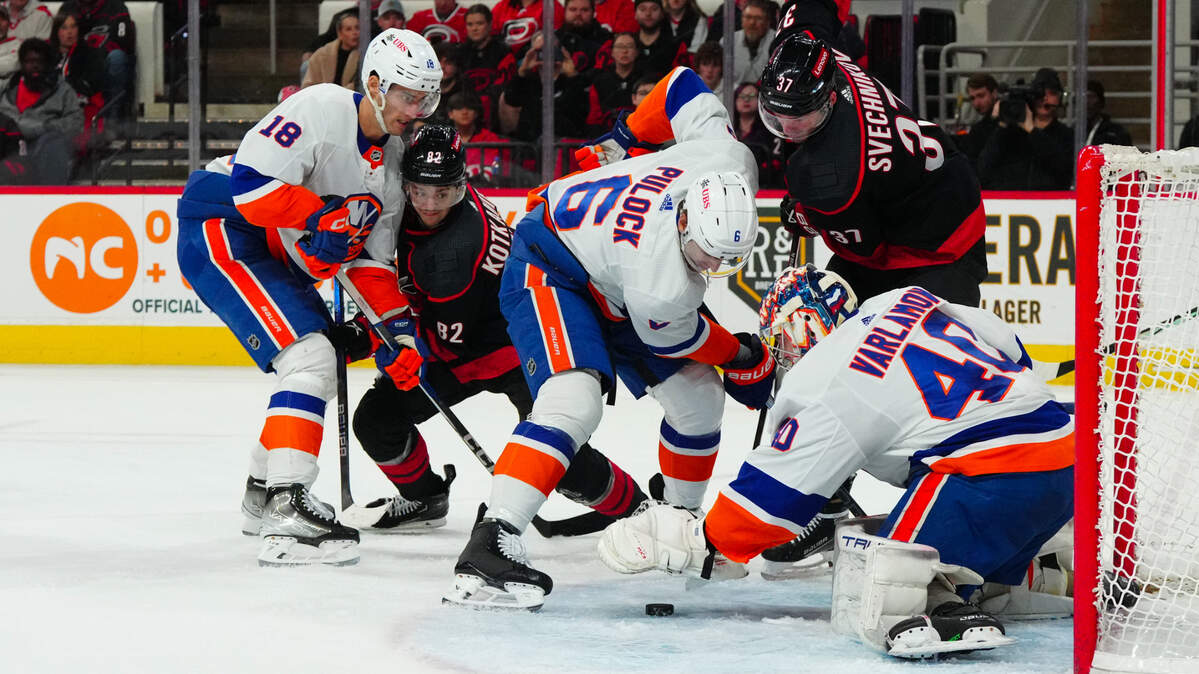 Nov 30, 2023; Raleigh, North Carolina, USA; New York Islanders goaltender Semyon Varlamov (40) defenseman Mike Reilly (6) and left wing Pierre Engvall (18) battle over the puck against Carolina Hurricanes right wing Andrei Svechnikov (37) and center Jesperi Kotkaniemi (82) during the first period at PNC Arena. Mandatory Credit: James Guillory-USA TODAY Sports