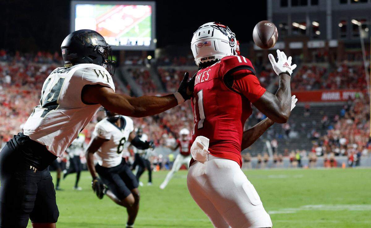 N.C. State wide receiver Darryl Jones (11) pulls in a 13-yard touchdown reception as Wake Forest defensive back Evan Slocum (14) defends during the first half of N.C. State’s game against Wake Forest at Carter-Finley Stadium in Raleigh, N.C., Saturday, Nov. 5, 2022.