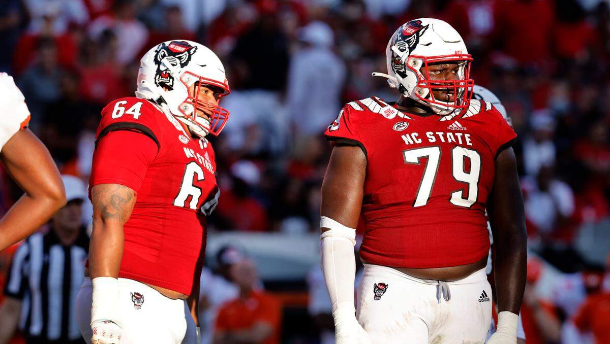 N.C. State’s Chandler Zavala (64) and Ikem Ekwonu (79) wait for the offense to huddle during the Wolfpack’s 27-21 overtime victory over Clemson at Carter-Finley Stadium in Raleigh, N.C., Saturday, Sept. 25, 2021.