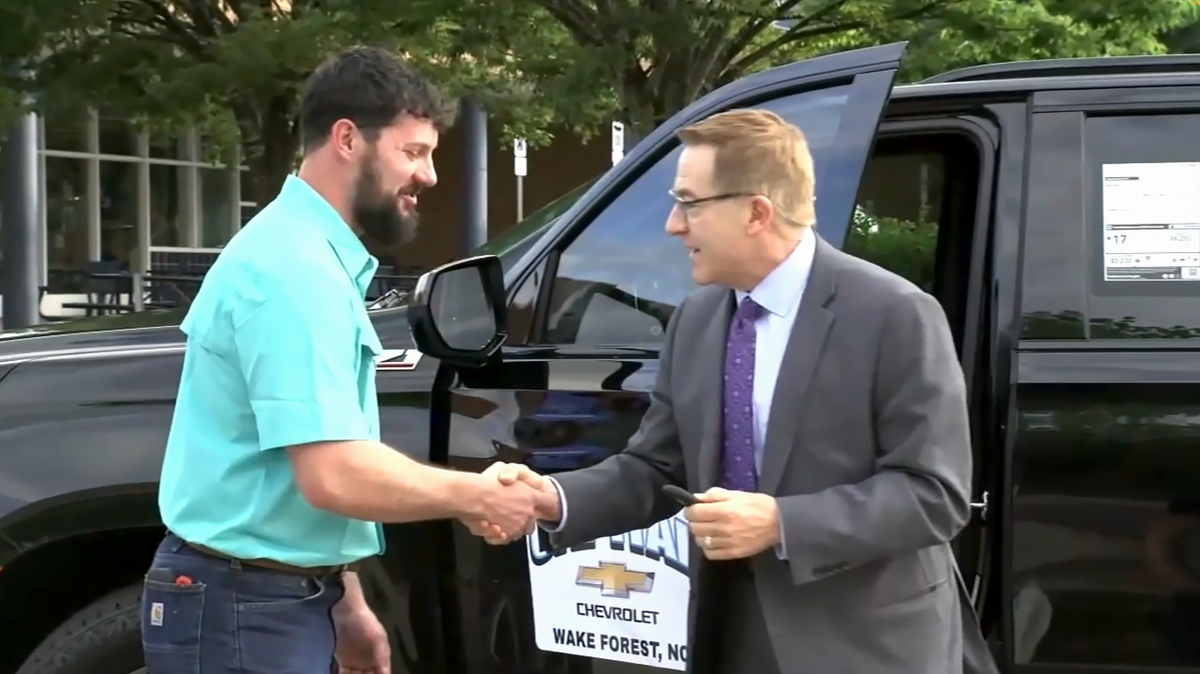 Ryan Berglund, left, a Sustainable Agriculture Academy teacher at Millbrook High School, is WCPSS school district’s 2024 Teacher of the Year. In addition to a $1,000 check, he’ll also get use of a 2024 Chevrolet Tahoe, compliments of Capital Chevrolet, for the next year.