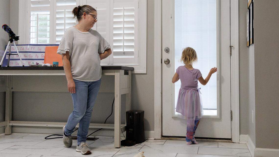 Brittany Futch watches as her daughter, Arya, 6, looks out the window of their home in Wake Forest. Futch is lobbying to get the Wake County school system to restore an extra aide’s position in Arya’s classroom at Heritage Elementary School. Arya has run away from her classroom multiple times since the aide was removed.