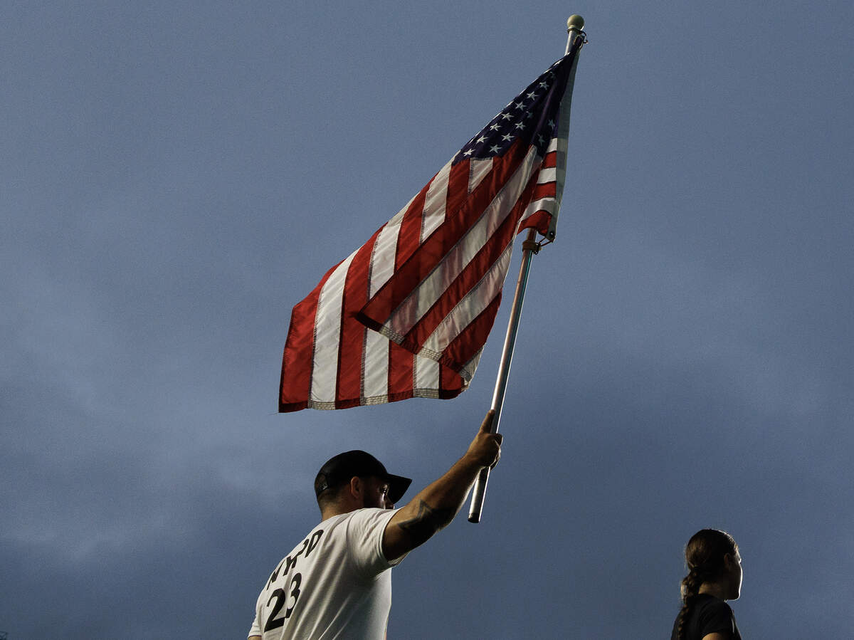 A person holds an American flag aloft during an event at Kenan Memorial Stadium on Thursday, Sept. 11, 2025, to honor those who lost their lives during the attacks of Sept. 11, 2001.