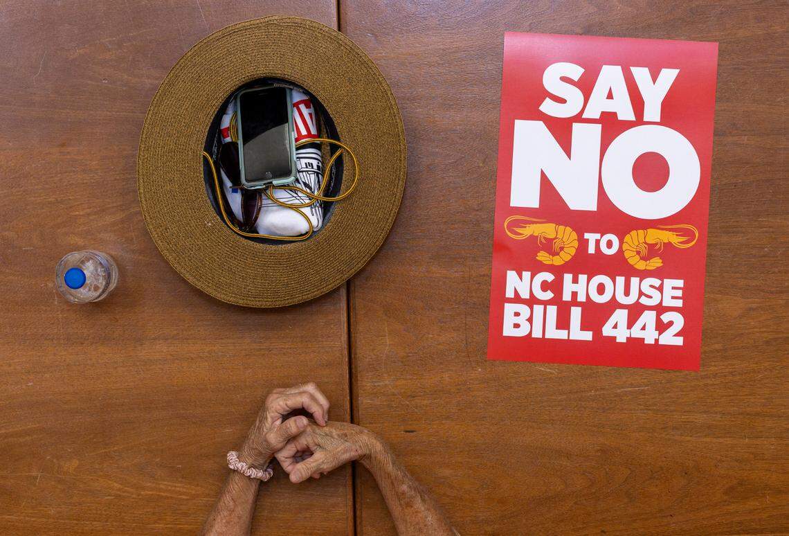 Sarah Willis, who works with Miss Gina’s Fish & Shrimp of Beaufort, N.C. waits with her belonging and poster opposing HB 442 at the North Carolina General Assembly on Tuesday, June 24, 2025 in Raleigh, N.C. Willis was among hundreds of people associated with the fishing industry that are opposed to HB 442, legislation that would prohibit shrimp trawling in all inshore fishing waters and within one-half mile of the shoreline.