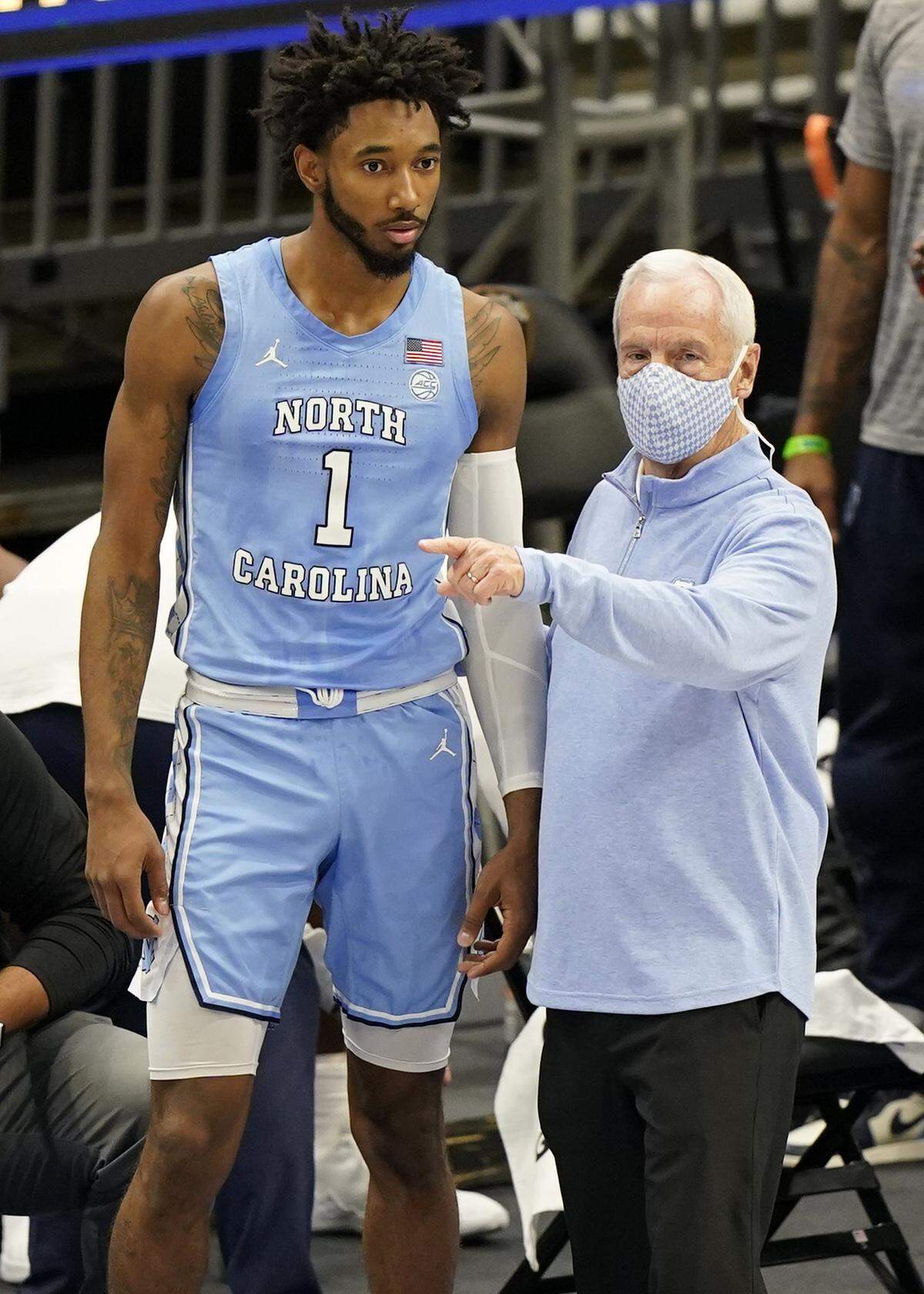 North Carolina head coach Roy Williams, right, talks with Leaky Black in the first half of an NCAA college basketball game against Kentucky, Saturday, Dec. 19, 2020, in Cleveland.