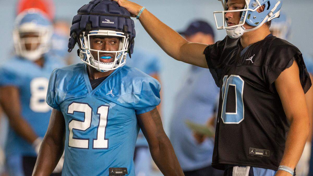 North Carolina quarterback Drake Maye (10) gives running back Elijah Green (21) a pat on the head during the Tar Heels’ first practice of the season on Wednesday, August 2, 2023 in Chapel Hill, N.C.