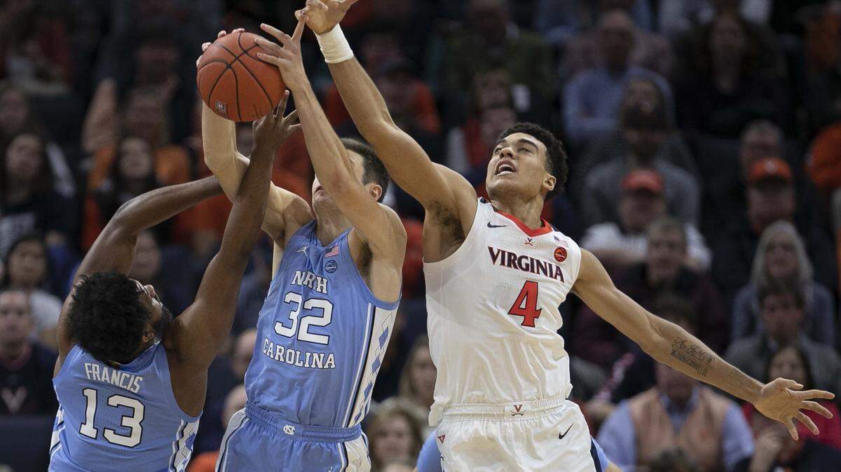 North Carolina’s Jeremiah Francis (13) and Justin Pierce (32) work to secure a defensive rebound from Virginia’s Justin McKoy (4) in the second half on Sunday, December 8, 2019 at John Paul Jones Arena in Charlottesville, Va.