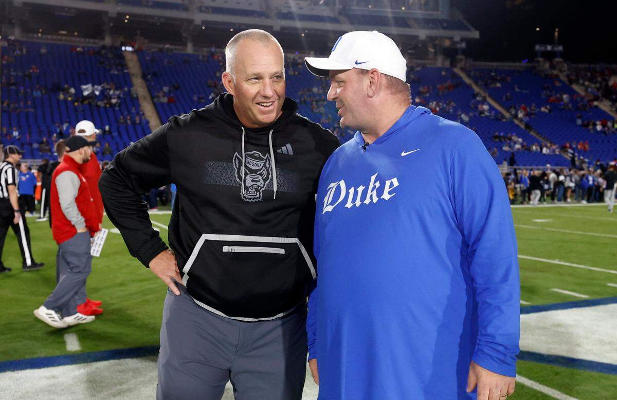 N.C. State head coach Dave Doeren talks with Duke head coach Mike Elko before the Wolfpack’s game against the Blue Devils at Wallace Wade Stadium in Durham, N.C., Saturday, Oct. 14, 2023.