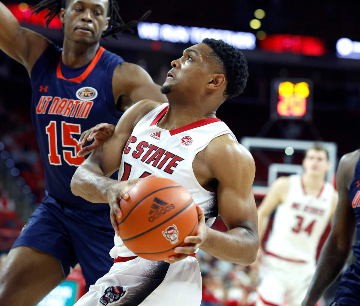 N.C. State’s Casey Morsell (14) drives by UT Martin’s Christian Fussell (15) during the first half of N.C. State’s game against UT Martin at PNC Arena in Raleigh, N.C., Tuesday, Dec. 12, 2023.